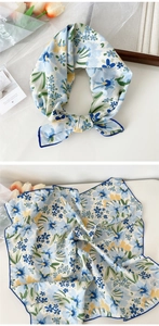 Flat lay of a floral cotton linen scarf with blue yellow prints and hand-stitched edges