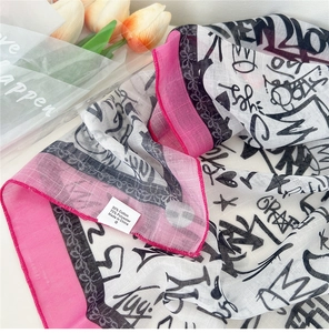 Détail d'une écharpe graffiti en coton et lin avec étiquette 30% coton et 70% polyester