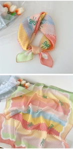 Détail d'un foulard en coton lin à rayures colorées avec motif nœud vert et tulipes