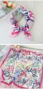 Détail d'un foulard carré en coton et lin avec imprimés graffiti et bordures roses