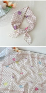 Détail d'un foulard en coton et lin avec imprimé floral de roses et motif à carreaux