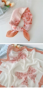 Détail macro du motif paisley et nœud sur un foulard en lin et coton aux bordures orange