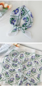 Détail d'un foulard carré en coton et lin avec imprimé floral violet et motifs ondulés verts