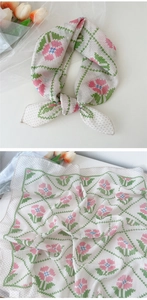 Détail d'un foulard en lin à motif tulipes roses avec bordures festonnées vertes