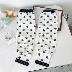 Detailed view of white sun protection sleeves with elegant black rose floral prints