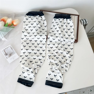 Detail of white cooling arm sleeves featuring black bow pattern and elastic cuffs