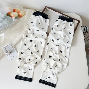 Detail of white cooling arm sleeves with black letter print and elastic cuffs