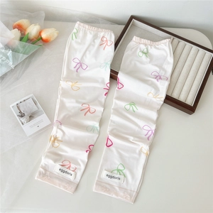 Détail de manchons blancs anti-UV avec motifs de nœuds colorés et bords élastiques