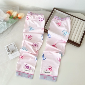 Détail de manchettes de protection solaire roses avec motif nœud et étiquette de marque