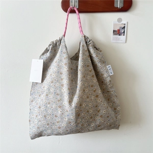 Close-up of floral tote bag showing seersucker texture and pink rope handles