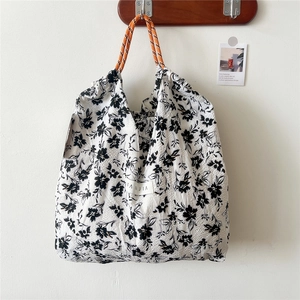 Close-up of floral tote bag with textured seersucker fabric and orange rope handles