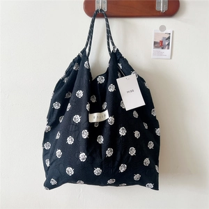 Detail of floral printed tote bag with pleated texture and stylish drawstring handles