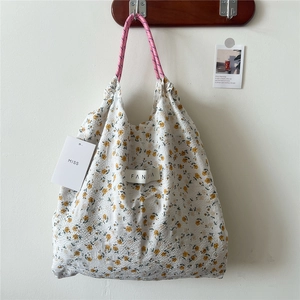 Detail of floral tote bag showing textured crinkled fabric and pink rope handle