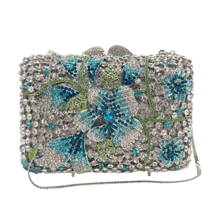 Détail de pochette de soirée en cristal avec motif floral en strass et chaîne argentée