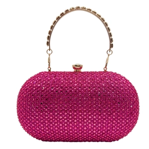 Macro shot of rose pink rhinestone clutch with golden crystal handle for evening parties