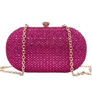 Detail of rose red rhinestone clutch with golden metal clasp and chain strap