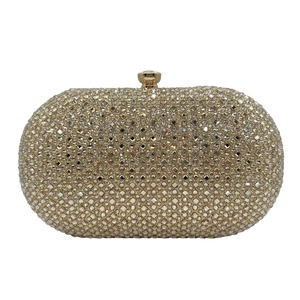 Detail of gold oval evening clutch bag with sparkling rhinestones and crystal clasp