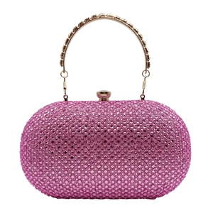 Close-up of pink rhinestone clutch with sparkling stones and gold handle detail