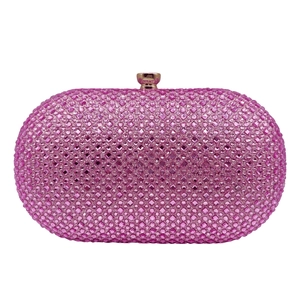 Detailed macro view of pink crystal rhinestones and golden ball clasp on clutch bag