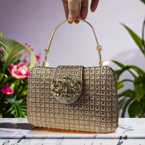 Detail of crystal clutch bag with a flower buckle and champagne gold rhinestones