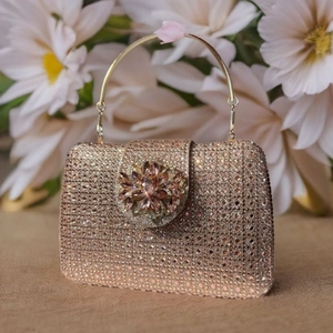 Macro detail of champagne crystal clutch bag with a large sparkling floral 3D ornament