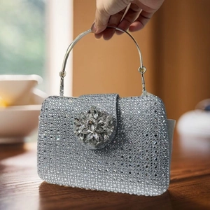 Detail of silver crystal evening clutch bag with sparkling rhinestones and floral ornament