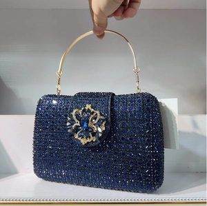 Close-up of luxury navy blue crystal evening clutch bag with golden ring handle