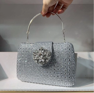 Detail of silver rhinestone evening clutch bag with large crystal flower clasp