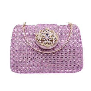 Detailed view of pink crystal clutch bag with floral rhinestone clasp and gold chain