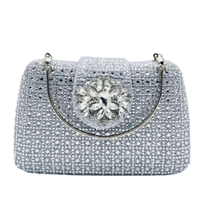 Macro shot of silver evening bag with crystal flower ornament and rhinestone surface