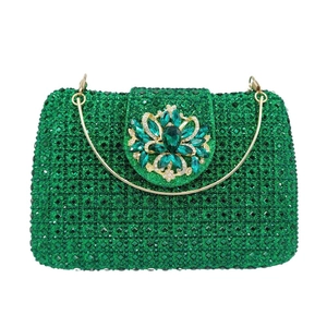 Detail of emerald crystal clutch bag with ornate gold floral gemstone clasp and ring handle