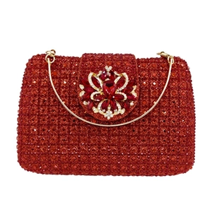 Macro shot of luxury red crystal clutch bag with ornate gold floral gemstone clasp
