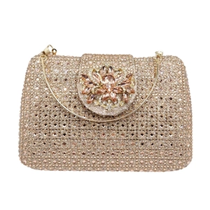Detail of champagne gold evening clutch featuring dense rhinestones and floral crystal clasp