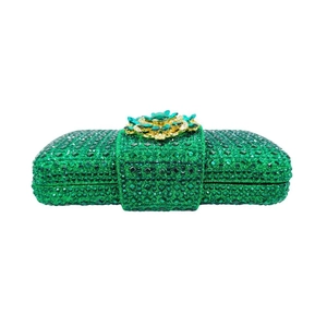 Detail of emerald green rhinestone clutch bag featuring a floral jewel clasp closure