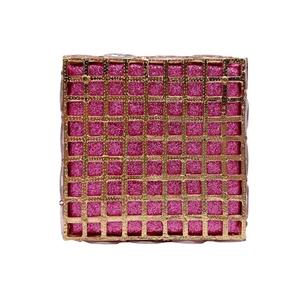 Detail of pink glitter jewelry clutch with gold geometric hollow metal frame and crystals