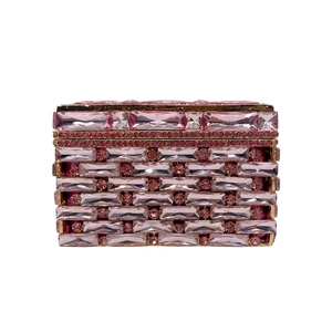 Macro detail of pink crystal encrusted evening clutch with premium gold metal frame