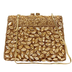 Close-up of golden evening clutch with rhinestone embellishments and filigree metal work