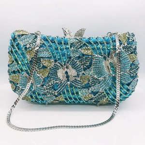 Detail of crystal peacock blue clutch bag showing butterfly metal clasp and sequins