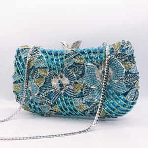 Detailed close-up of blue butterfly rhinestone patterns and metallic clasp on clutch bag