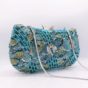 Macro detail of butterfly evening clutch with blue and green crystals and silver chain