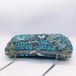Detail of luxury hollow metal clutch bag with blue butterfly rhinestone floral patterns