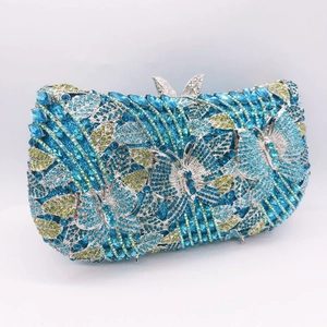 Detailed view of luxury clutch featuring butterfly pattern with blue and green crystals