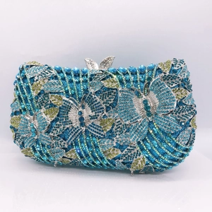 Detailed view of hollow metal butterfly clutch with blue and green rhinestones and top clasp