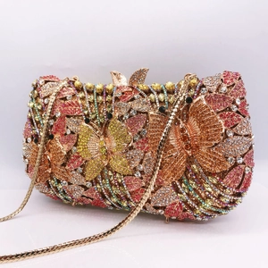 Macro view of crystal encrusted butterfly evening clutch with gold metal leaf clasp