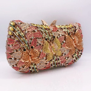 Macro view of crystal encrusted butterfly and flower motifs on luxury evening clutch bag