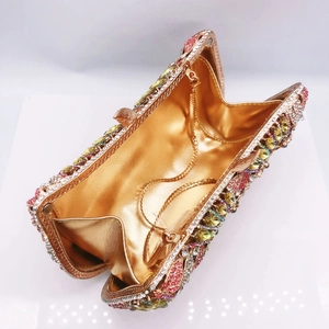 Macro shot showing crystal rhinestones, metal leaf detail and golden lining of the clutch