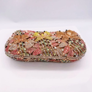 Macro view of crystal encrusted butterfly and floral patterns on luxury metal clutch bag