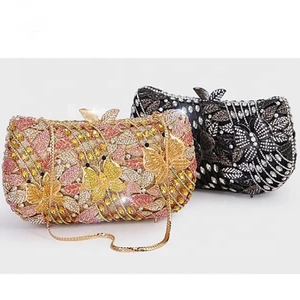 Detail of evening clutch bags with butterfly floral crystal patterns and metal chain