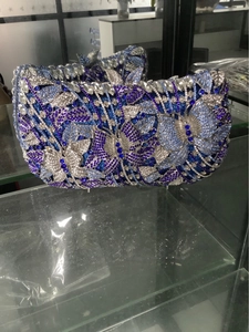 Detailed close-up of blue and silver crystal butterfly pattern on luxury evening clutch bag