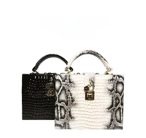 Détail de sacs à main structurés en crocodile noir et imprimé python avec fermoir doré